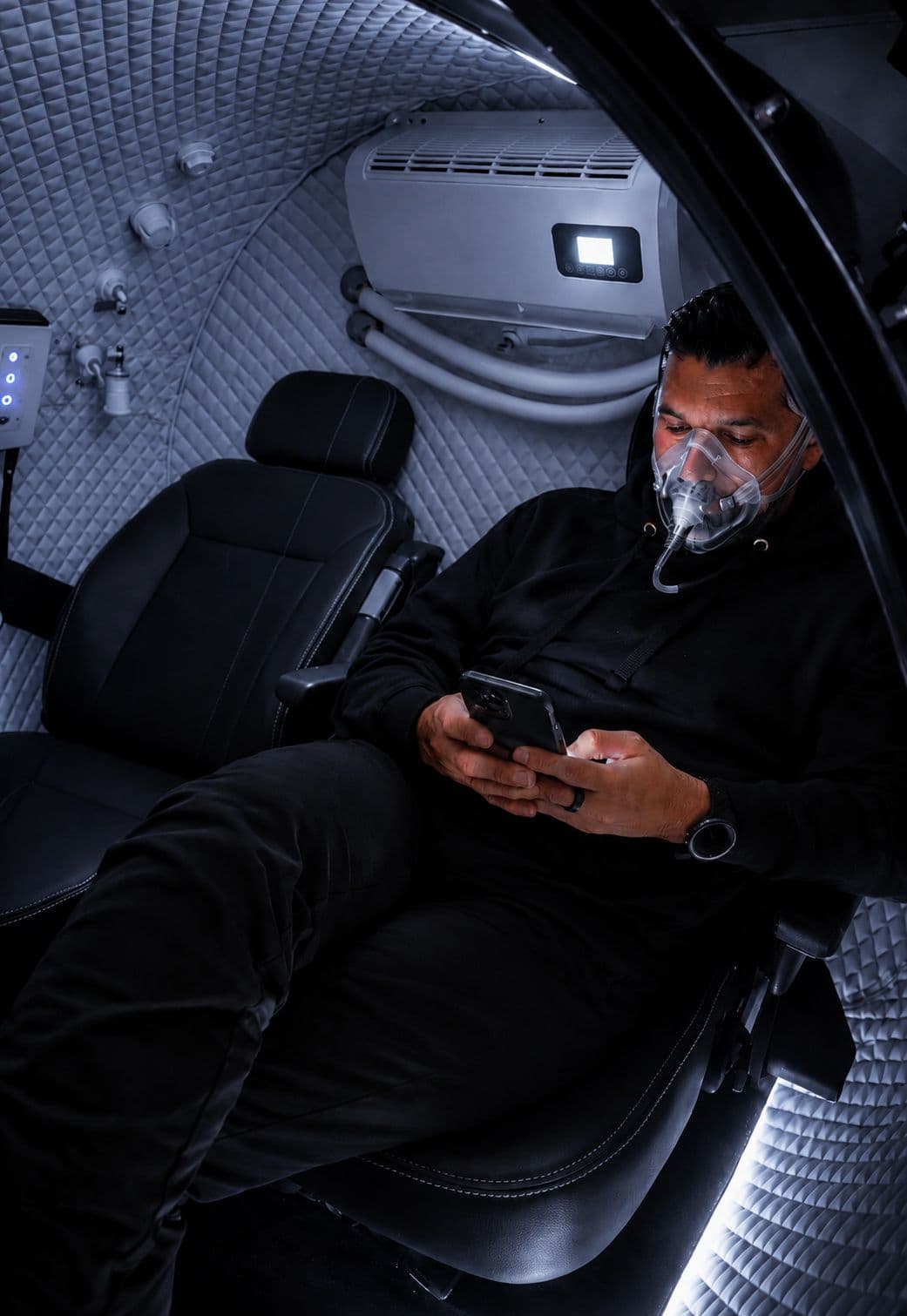 Man inside 3-person hyperbaric oxygen chamber at Eleve Lakewood
